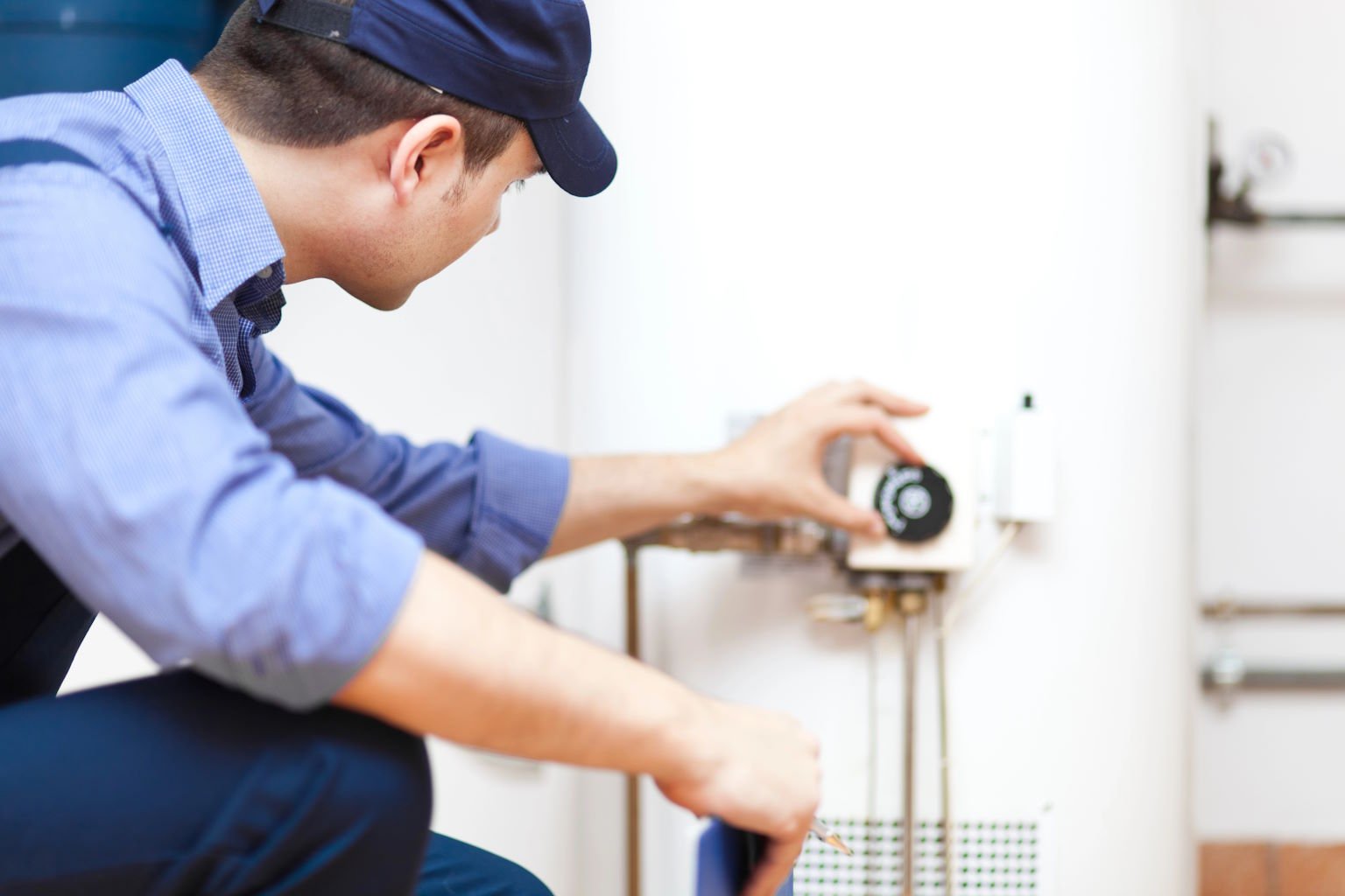 Plumber adjusting a wall-mounted water heater (demo image)